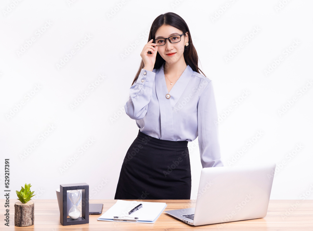 A business woman standing at her desk in a short black dress A business woman standing at her desk in a short black dress