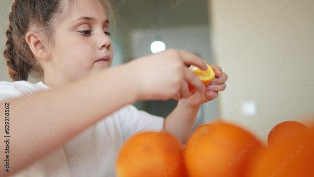 girl child eating oranges. dream happy family fruit healthy food kid concept. little girl daughter eating oranges at the table in the kitchen. juicy fruits oranges are for indoor a healthy diet girl child eating oranges. dream happy family fruit healthy food kid concept. little girl daughter eating oranges at the table in the kitchen. juicy fruits oranges are for indoor a healthy diet