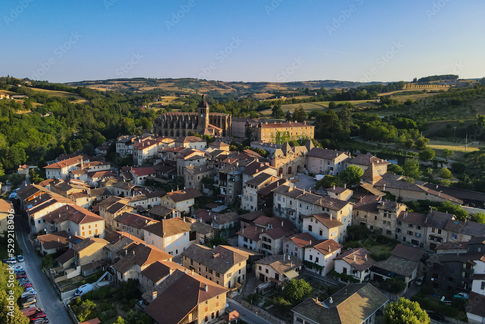 Fototapeta premium Early morining aerial sunrise shot of Saint-Antoine-l'Abbaye the Morning of the summer médiéval festival