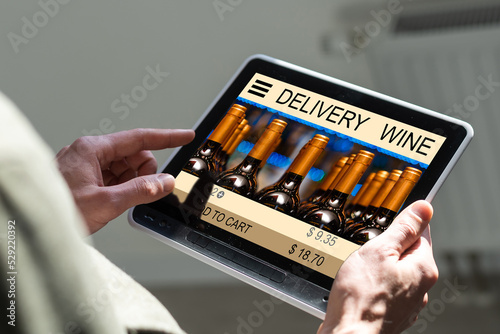 hands holding digital tablet with app delivery food wine screen.
