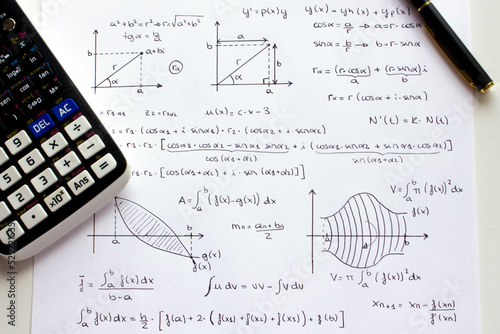Photos Sheet of paper with science background and math formulas written by hand with calculator and pen
