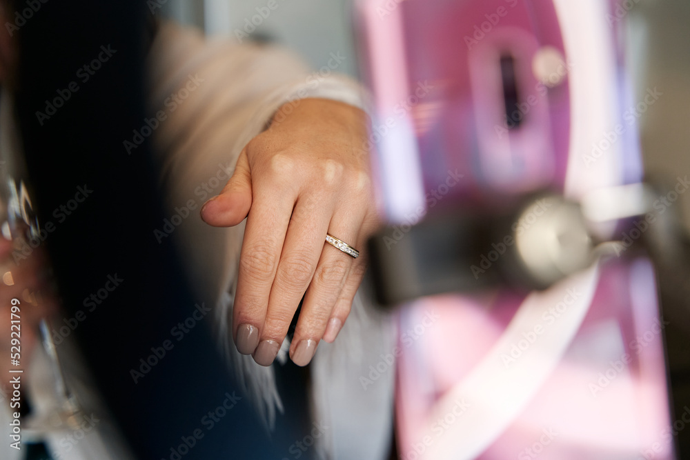 closed up of a young influencer woman's hand in the middle of a video call with her phone, showing her engagement ring