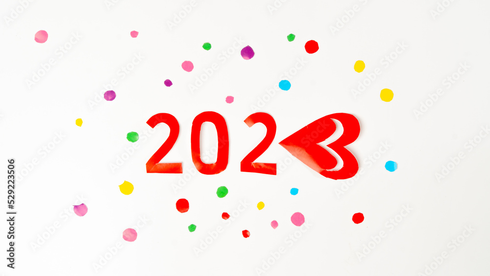 The number 2023 in red in multi-colored confetti, new year with love