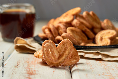 Puff pastry cookies palmier or elephant ears, caramelized and crunchy pastry with coffee. Focus selective. photo