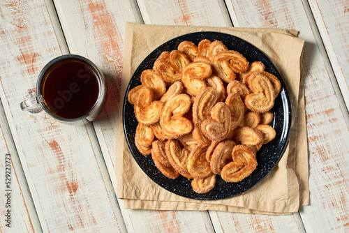 Puff pastry cookies palmier or elephant ears, caramelized and crunchy pastry with coffee. photo