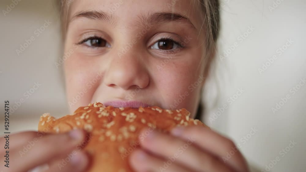 little kid girl eating a hamburger. unhealthy fast food meal lifestyle