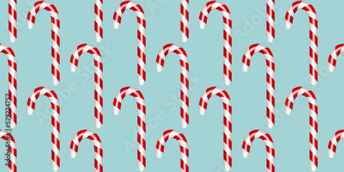 Candy cane on a blue background Seamless pattern. Christmas background. Vector illustration.