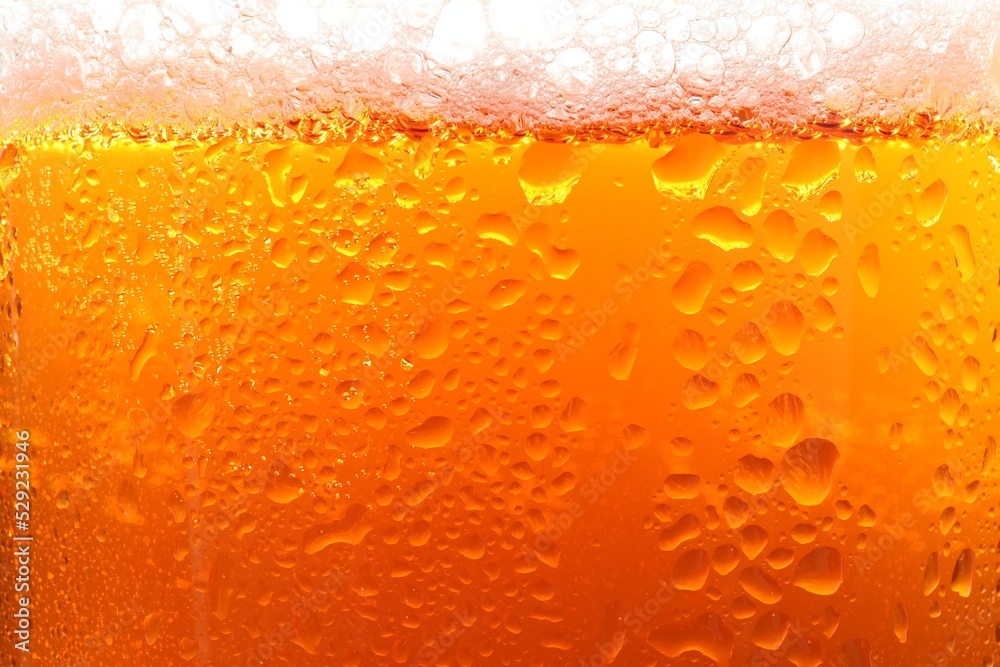 Glass of tasty cold beer with foam and condensation drops as background, closeup Glass of tasty cold beer with foam and condensation drops as background, closeup