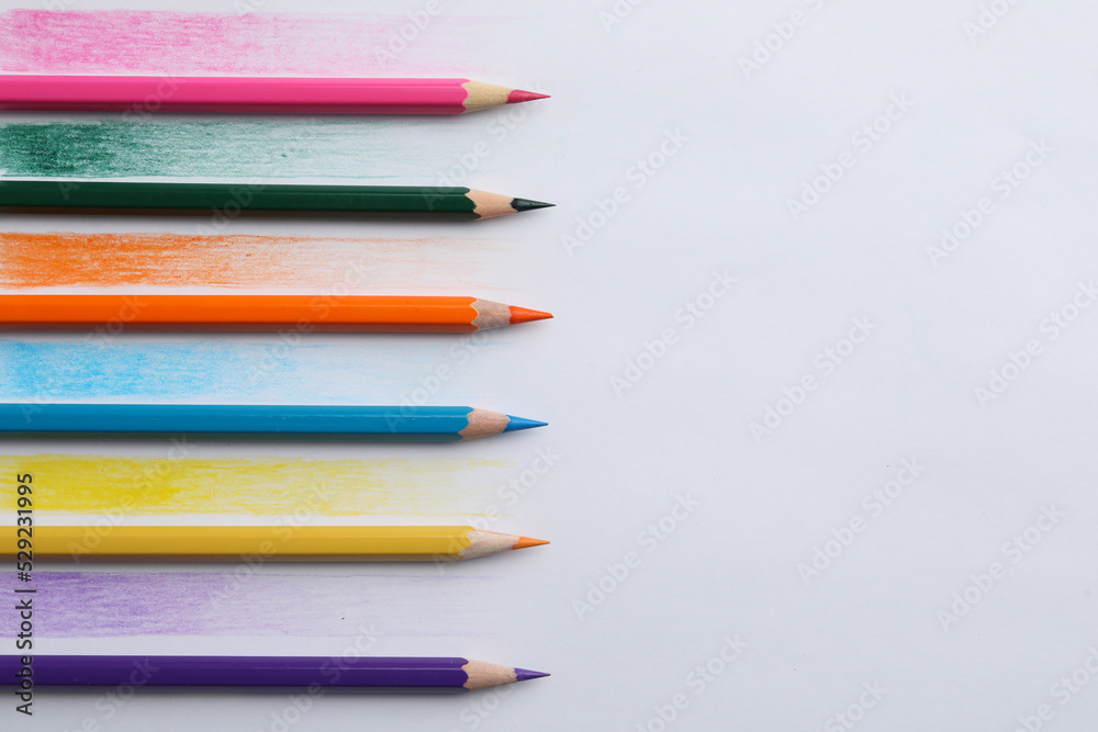 Colorful pencils with swatches on white background, top view Colorful pencils with swatches on white background, top view
