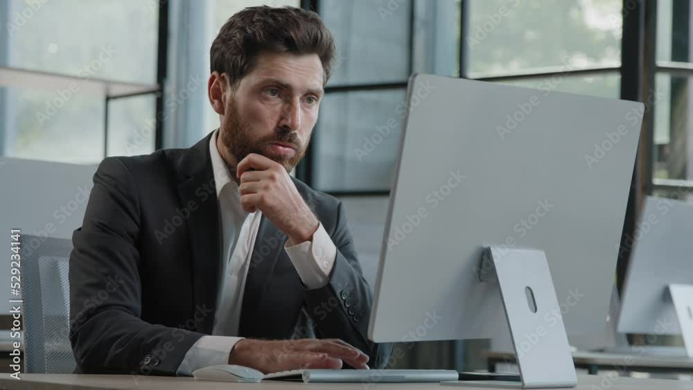 Focused Caucasian bearded adult 40s man CEO company worker manager boss businessman working on computer in office searching solution of problem decide difficult task creating online project thinking