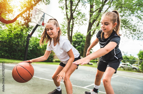 two girl child in sportswear playing basketball game © Louis-Photo