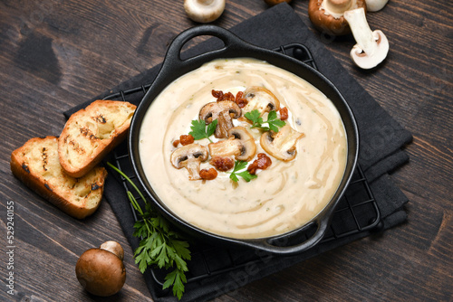 Mushroom soup with bread and fresh mushrooms on a wooden background , autumn seasonal cream soup with vegetables 
