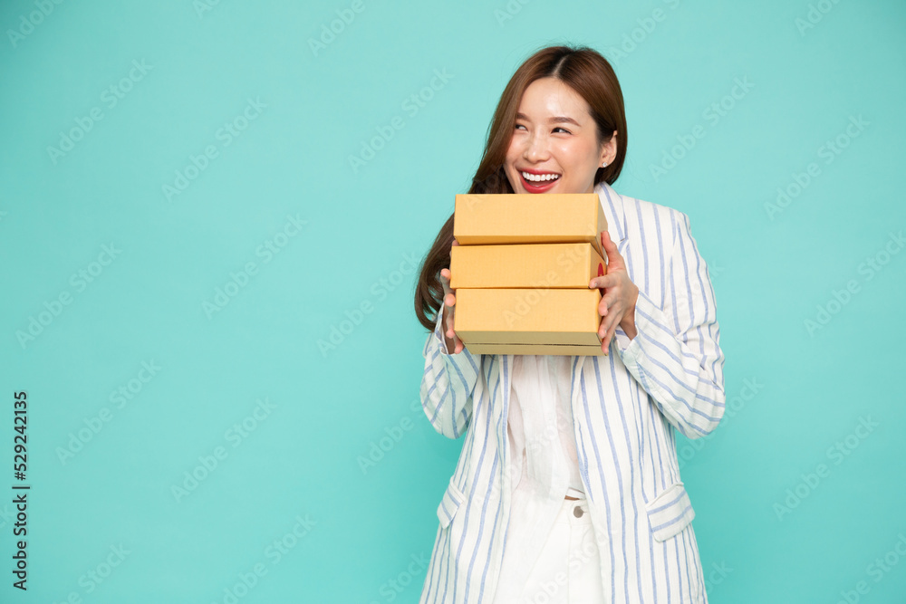 Happy Asian woman holding package parcel box isolated on green background, Delivery courier and shipping service concept Happy Asian woman holding package parcel box isolated on green background, Delivery courier and shipping service concept