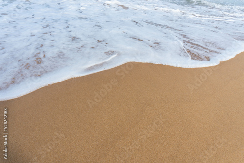 Sea waves with foam on white tropical sandy beach