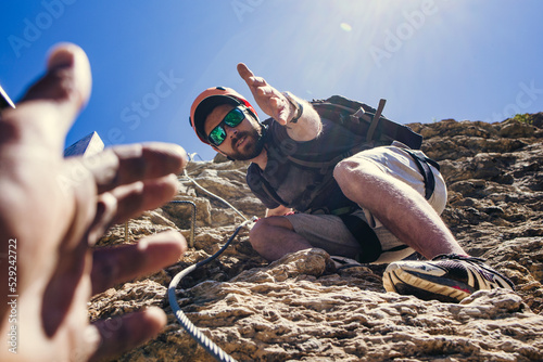 Help and assistance concept. Two people climbing on mountain and helping.