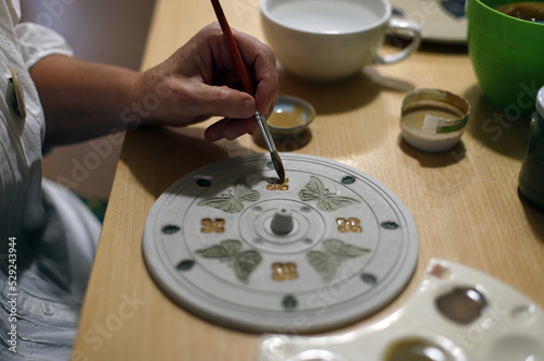 Konstfotografi mano pintando la decoración de cerámica artesanal con pincel