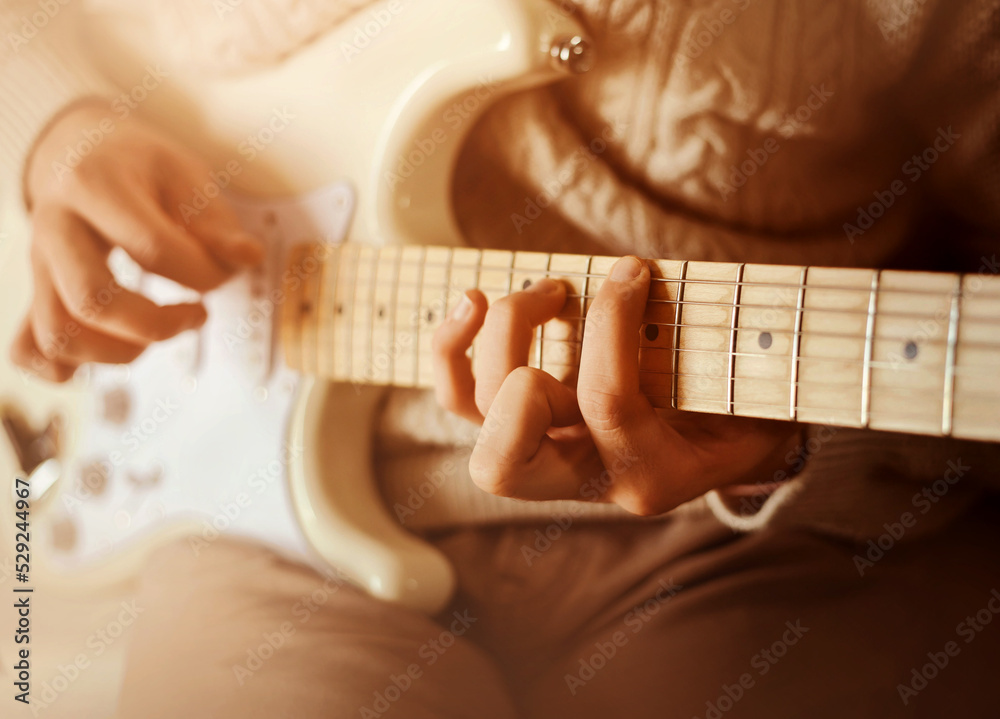 Foto de A man in a white wool sweater plays a melody on a white