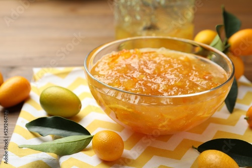Delicious kumquat jam in bowl and fresh fruits on table, space for text Fototapet