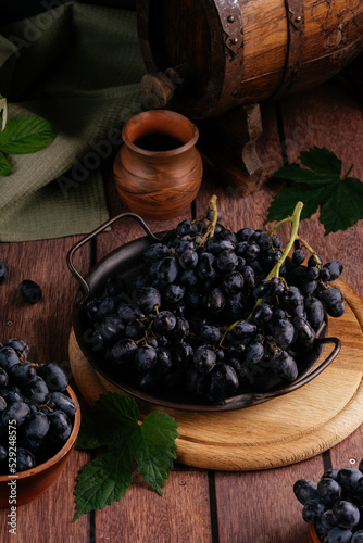red grapes on a vintage metal tray with a wooden barrel on the b
