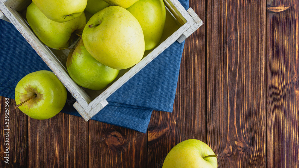 Yellow apples in a crate on a wooden background Yellow apples in a crate on a wooden background