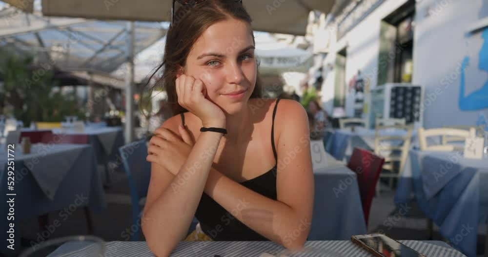 Beautiful young woman looking into the camera at the table slow motion Beautiful young woman looking into the camera at the table slow motion