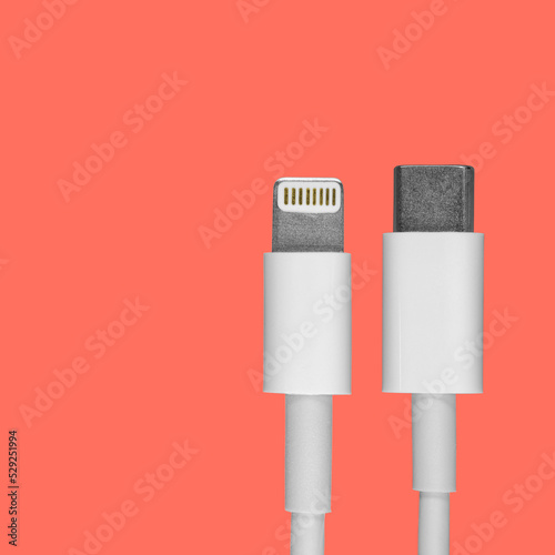 Data usb lightning cable lugs for a smartphone on a coral background, a mockup of an advertising cover for a product for an online store