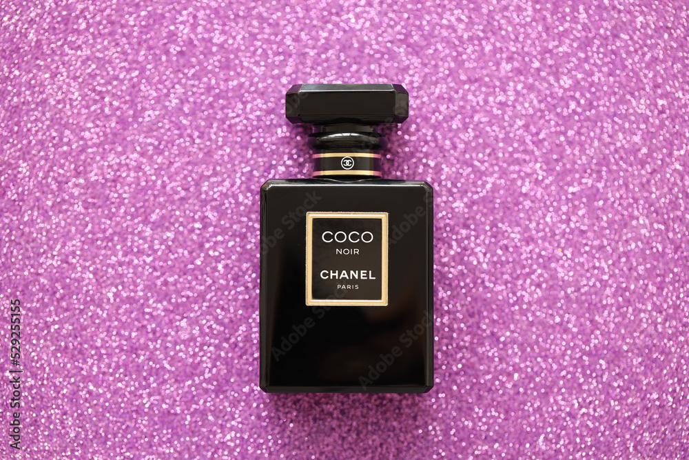 TERNOPIL, UKRAINE - SEPTEMBER 2, 2022 Coco Noir Chanel Paris worldwide  famous french perfume black bottle on shiny glitter background in purple  colors Stock Photo