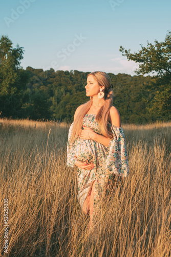 portrait of beautiful happy pregnant woman in countryside during sunset
