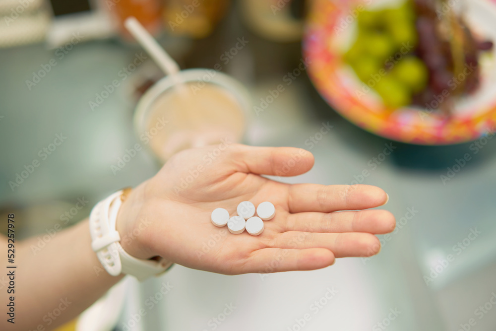 hand hold pills for supplements on blur food and drinks background obesity concept hand hold pills for supplements on blur food and drinks background obesity concept