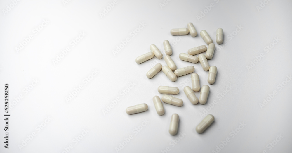 White tablets on a white isolate. Capsules of white color with medicine on a light background, a clean place for the text. White tablets on a white isolate. Capsules of white color with medicine on a light background, a clean place for the text.