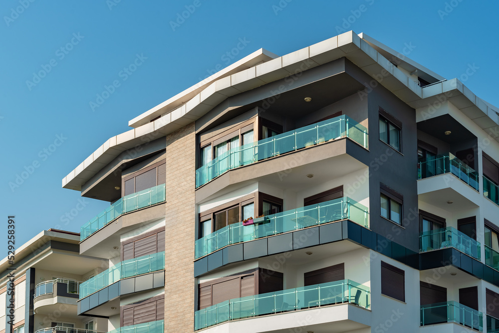 Image of the exterior of a residential building against a blue sky. Image of the exterior of a residential building against a blue sky.