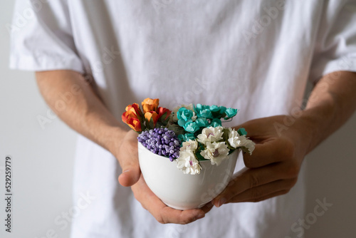 creative concept  person holding a white cup with flowers inside