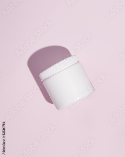 White plastic supplement container on pink background. Package mockup blank for capsule.