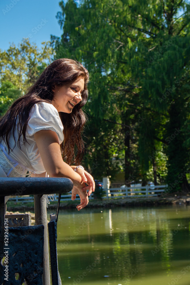 Naklejka premium A beautiful girl in a white dress by the lake