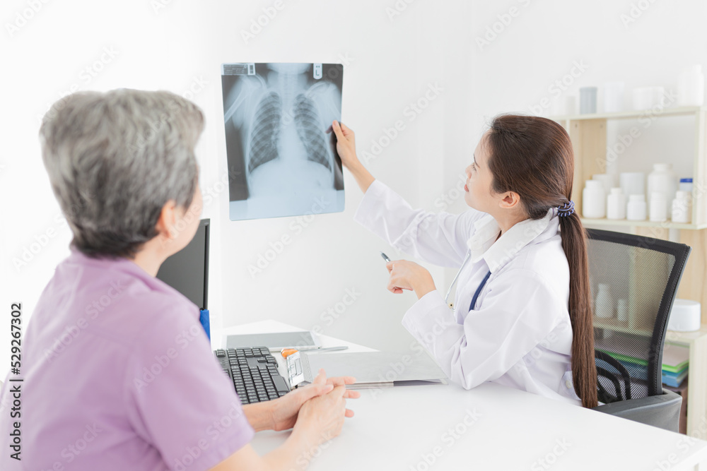 Obraz premium asian doctor looking patient film, he talk about symptoms and treatment plan of patient, he explain about disease with old patient, broken bone treatment, tuberculosis screening