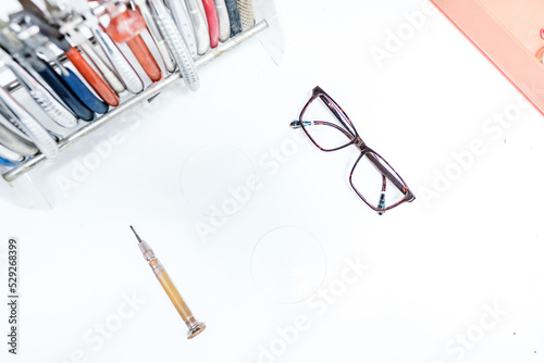 Glasses and screwdriver on table in optic office photo