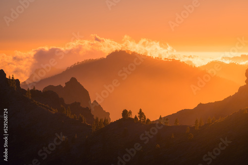Amazing bright sunset over rocky cloudy mountains photo