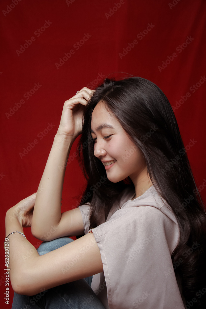 Asian woman taking photo on a red background. Happy Asian woman. Beautiful asian woman with long and straight hair. Asian woman taking photo on a red background. Happy Asian woman. Beautiful asian woman with long and straight hair.