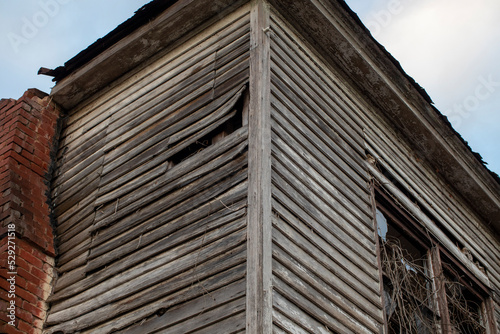 Old wooden weathered dilapidated abandoned two story house corner building