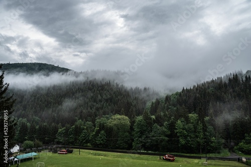 Aerial view of lush green Horni Lomna with foggy green forests in the background photo