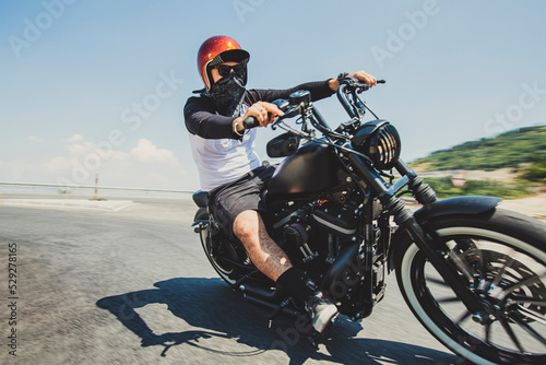 Man riding cruiser motorcycle on road against sky photo