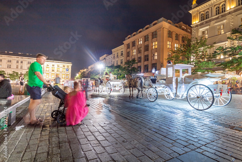 Krakow city in the evening in Poland  Main Square in the Old Town  illuminated St. Mary Church and Cloth Hall  Sukiennice .