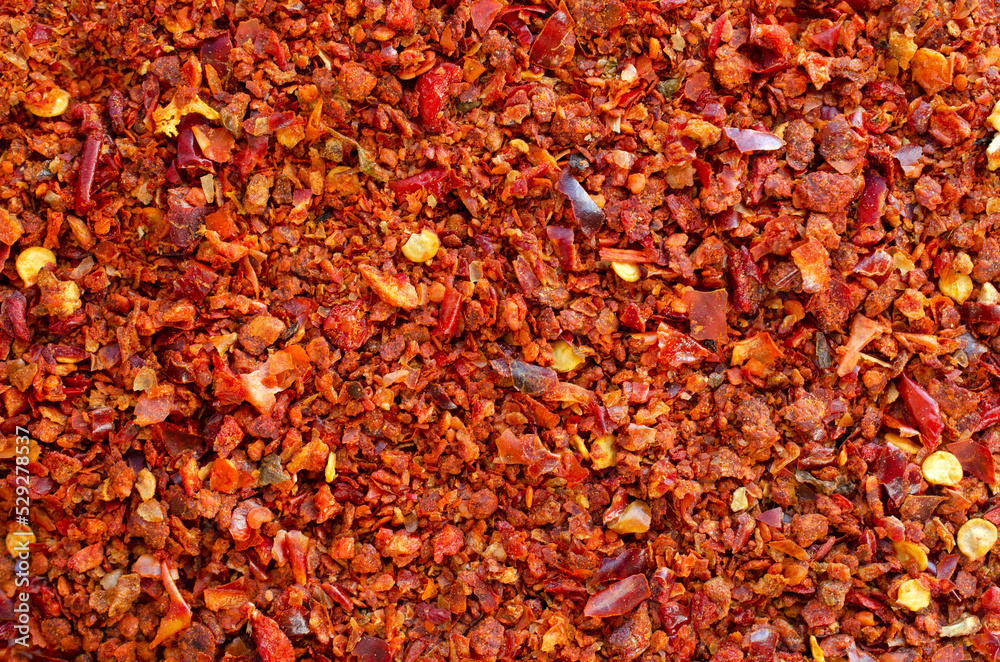 Background of crushed red cayenne pepper, dried chili flakes and seeds