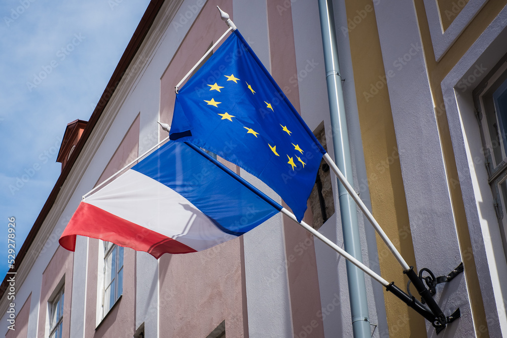 EU and French flags hanging together on a building. European Union and France.