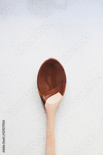 Overhead view of spoon with chocolate sauce on kitchen counter photo
