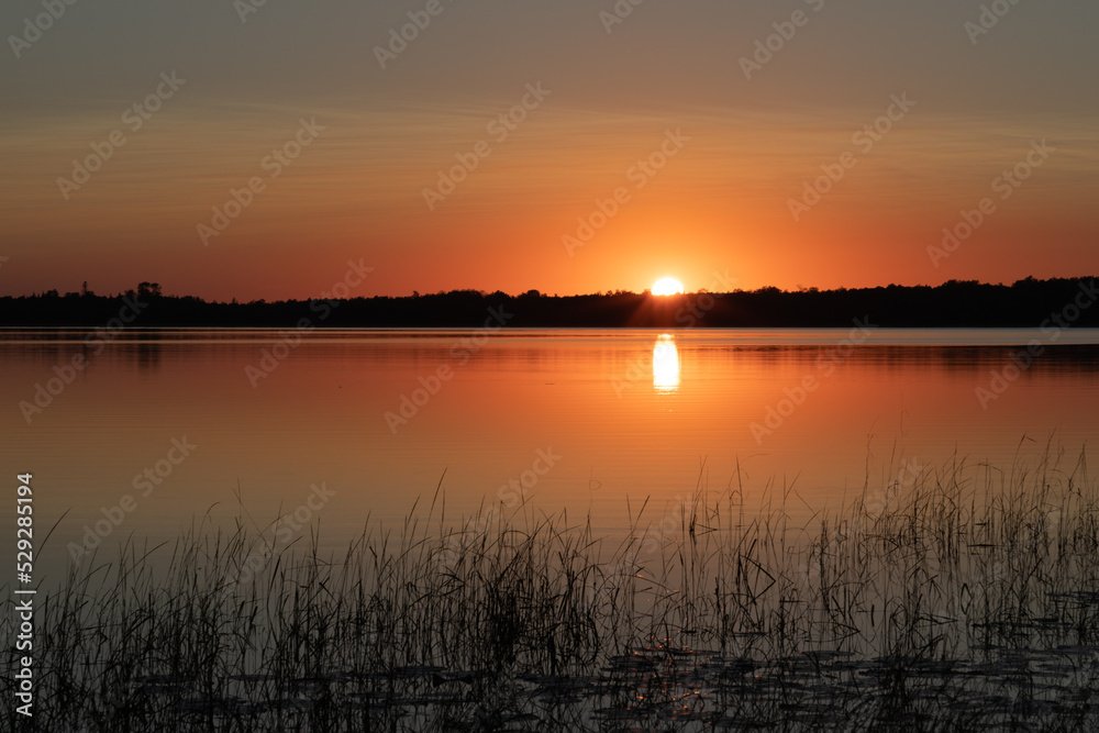 Deep golden sunset over northern Minnesota lake in late summer