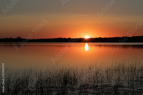 Deep golden sunset over northern Minnesota lake in late summer