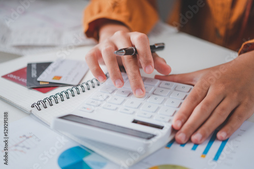 business person sitting at a desk at an office By using the calculator to work. Business Concept Analysis and Planning.