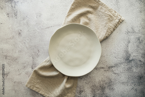 Top view white ceramic plates tableware with natural table napkin linen and light background photo