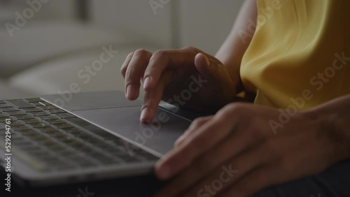 Close up of African Amerian woman hands using laptop touchpad - pinch, swipe and scroll